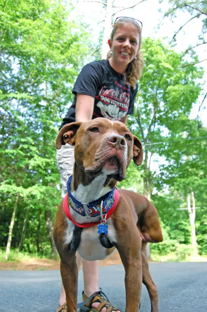 A woman is riding on the back of a dog.